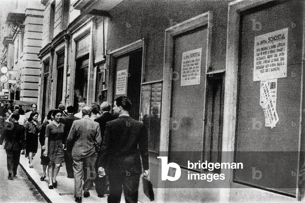 "Antisemitismus in der Ära des faschistischen Italiens: Passanten gehen gleichgültig vor einem Geschäft jüdisc