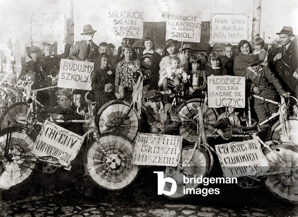 Szczecin near Lomza, Inter-war Poland, 1932-1938; Everyday life at Polish - Jewish public school number 2. Students during fund-raising with charity slogan placard on their bikes encouraging to donate schools.
