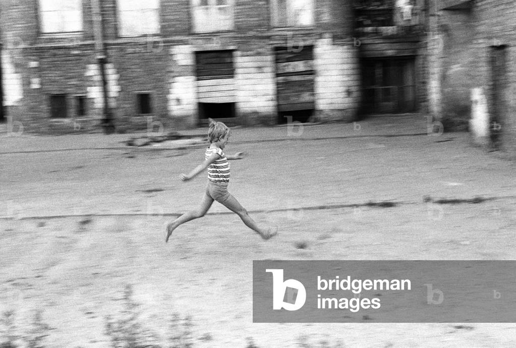 Warsaw, Poland, 1976. Tenement house on Grzybowska street. Boy running across the courtyard. 