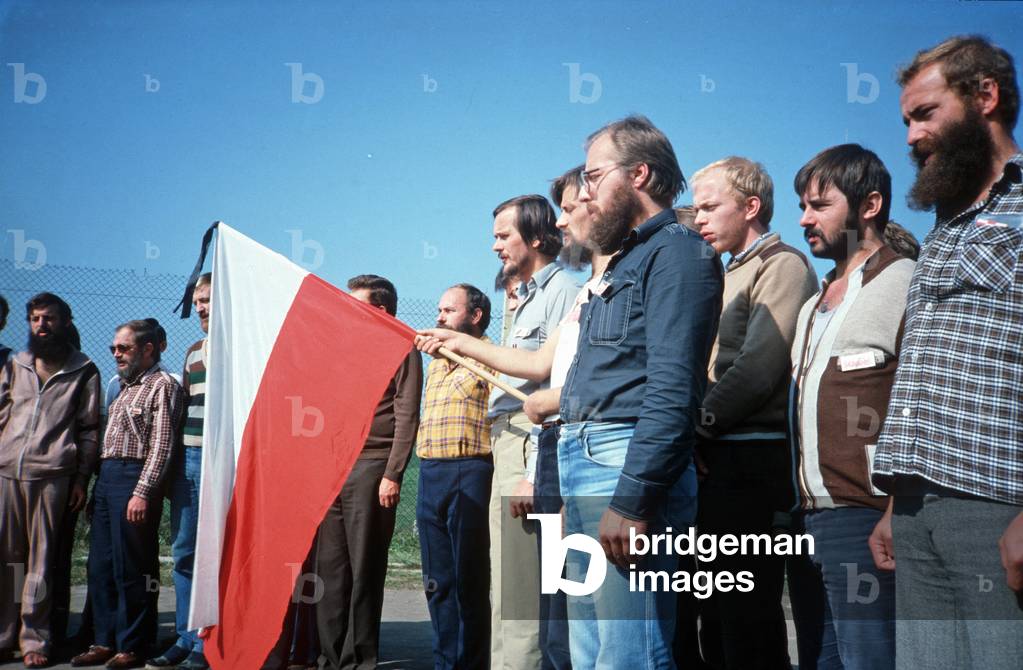 Uherce, 30.09.1982. Internmentees during martial law period in Poland. Anniversary of Protests in Lubin (31.08.1982, 3 people died during the demonstrations). Photographed from left: Janusz Romaniszyn, Stanislaw Lebrowski, Antoni Grabowski (half hidden by flag), right from flag in checkered shirt: Karol Blaszczyk, Alfred Cofalik, Chrystoforosz Tulasz, Piotr Ziemacki and Jacek Nowak. 