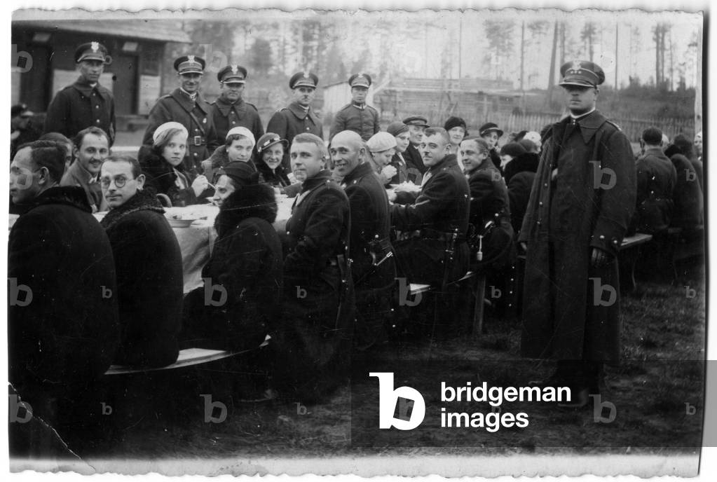 Inter-war period Poland, 1932. Picture from Zofia Jakubowska's family album (from Sejny). Soldiers during open air dinner in company of civilians. 