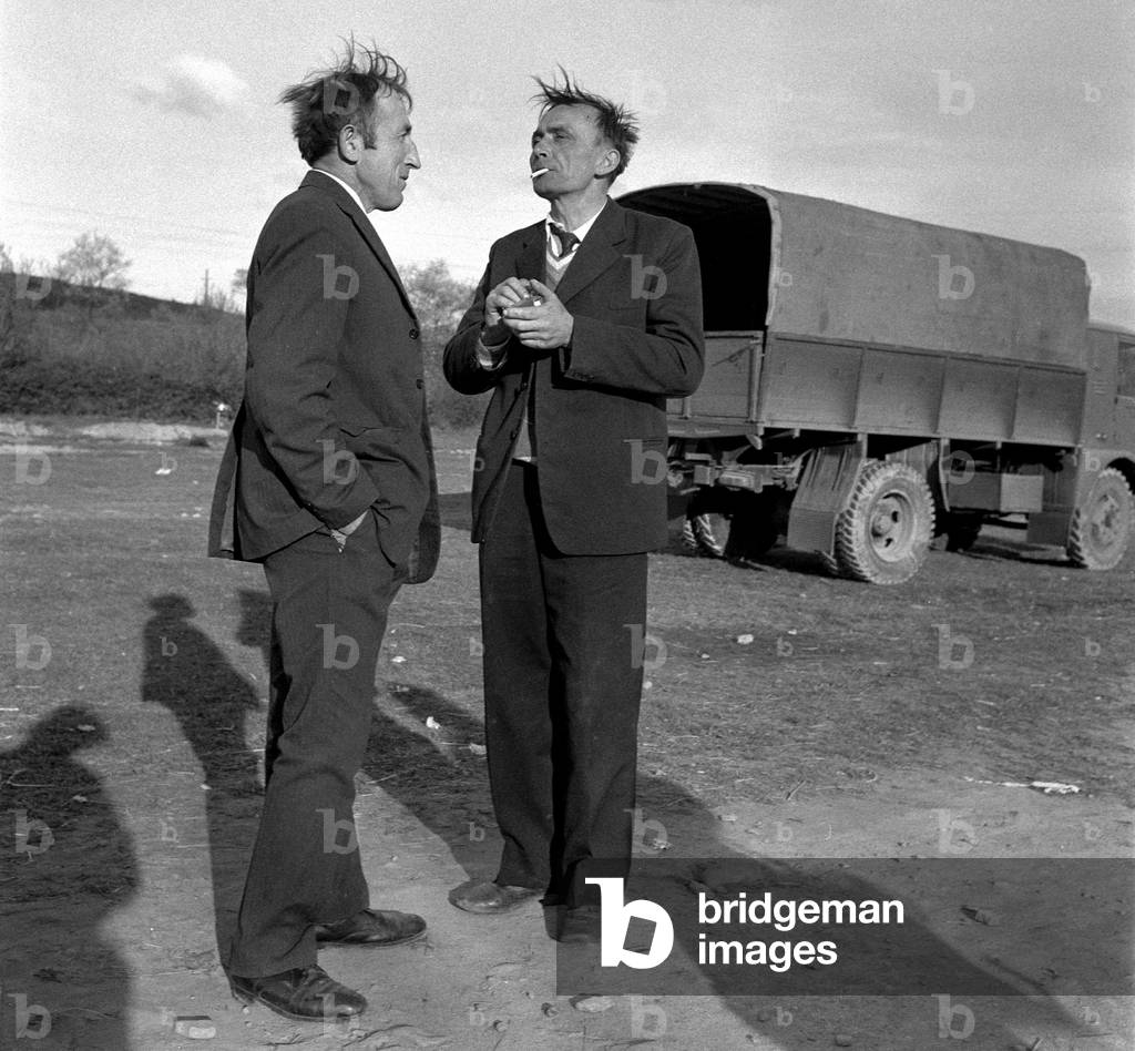 Poland, 05.1974, Two men standing and chatting near truck. 