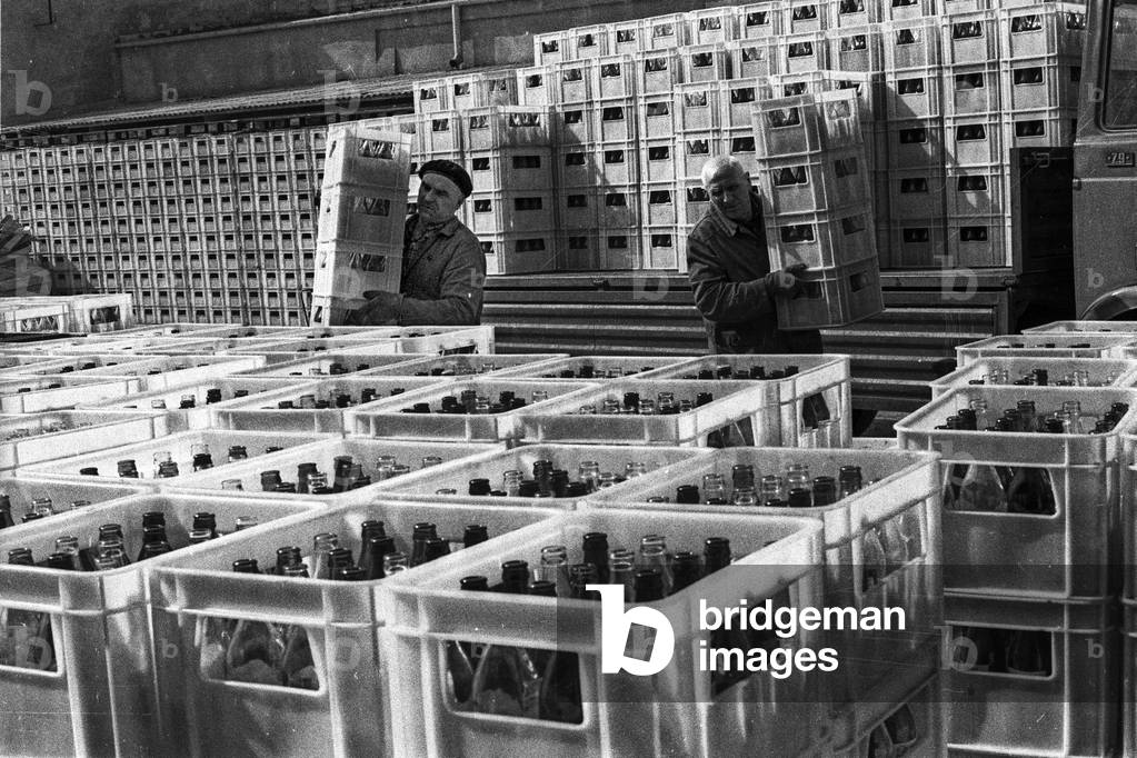 Warsaw Poland, 16.04.1979. Workers unloading boxes with empty wine bottles from a truck in Warsowin factory. Warsowin produced wines and other alcohols. 