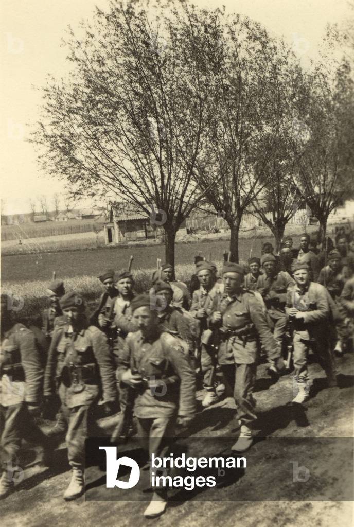 Poland, Inter-war period. Polish army marching in uniforms on a country road. The picture was found stuck in a German Wehrmacht soldier's album. 