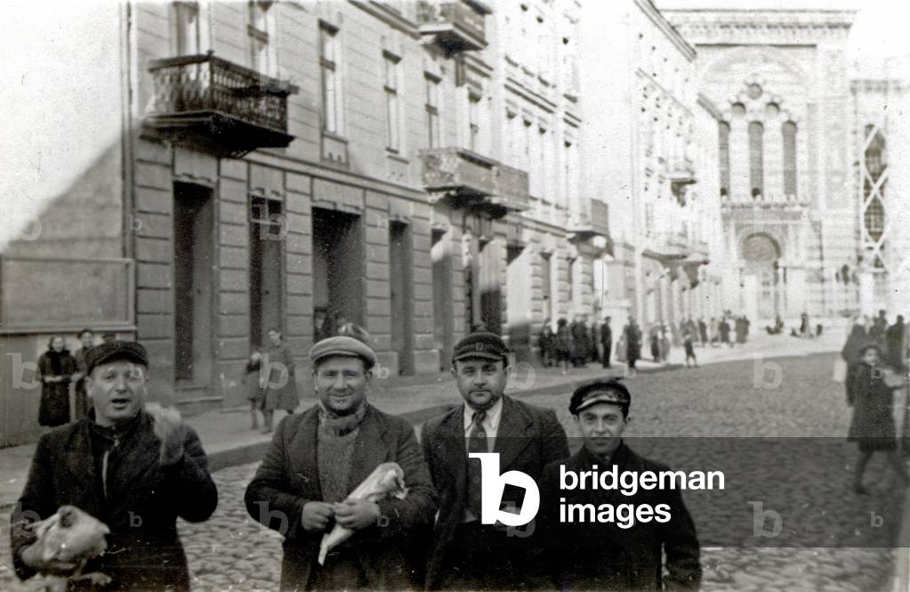 Lodz 1939. Jews without arm bands in the ghetto, Synagogue which will soon be burnt in the background. 