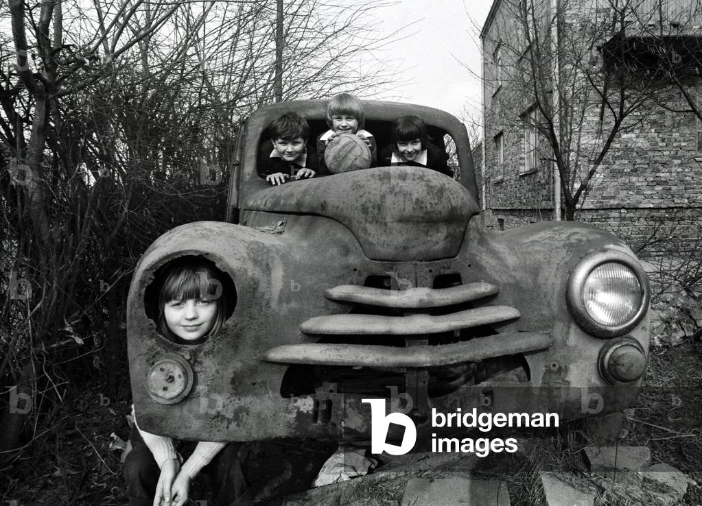 Warsaw, Poland, 03.1977. Kinds playing in the derelict car owned by a car collector. 