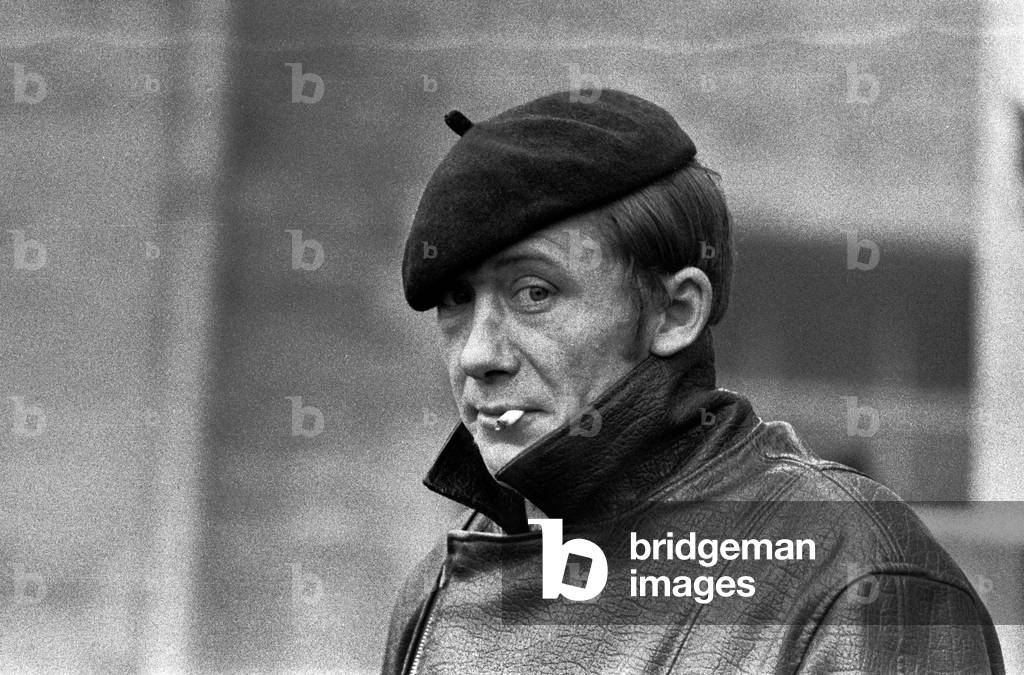 Plonsk, Poland, 12.1971. Portrait of an adult man in beret and leather coat smoking cigarettes. 