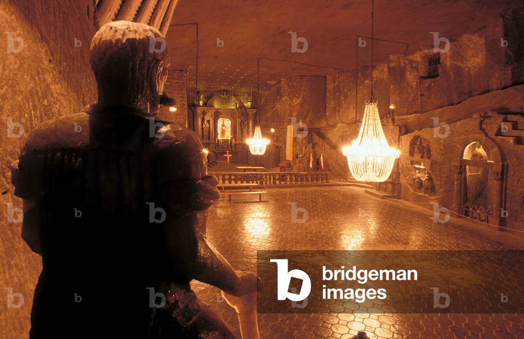 Wieliczka, Salt mine. The Wieliczka Salt Mine is one of the world's oldest operating salt mines, which has been in operation since prehistoric times. The mine reaches down to a depth of 327 meters, and is over 300 km long. The Wieliczka salt mine features a 3.5-km tourist route (less than 1% of the length of the mines passages) that includes statues of historic and mythic figures, all sculpted by miners out of the rock salt. Even the crystals in the chandeliers are fashioned of salt. Also featured are beautifully carved chambers, chapels, an underground lake, and exhibits on the history of salt mining. The mine is justly referred to as the underground salt cathedral of Poland. Some 800,000 persons visit the mine each year. 