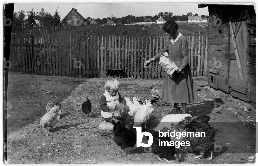 Suwalszczyzna, Inter-war eriod Poland. Picture from Andrzej Sidors archive. Child and woman feeding hens at farmyard. 