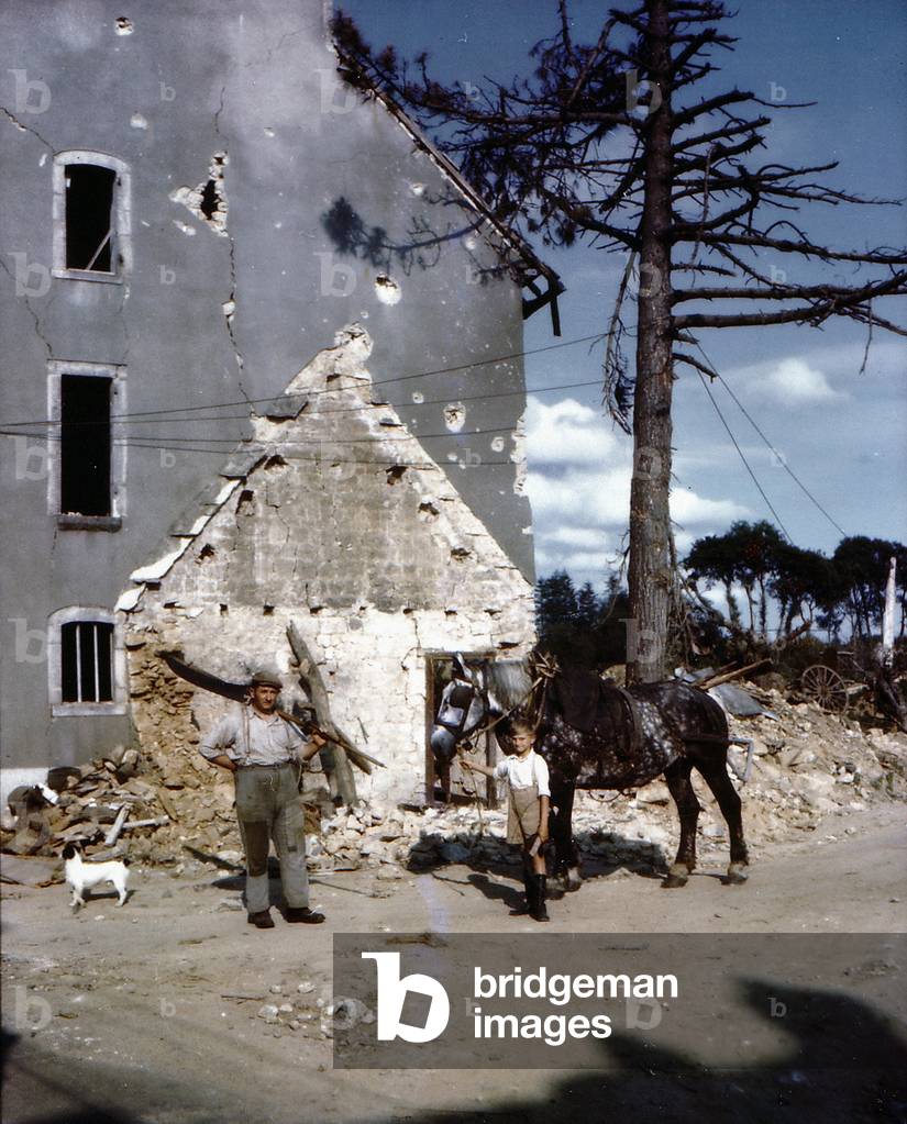 A farmer and his son in front of their damaged house during the battle between Allied and German troops, Normandy, France, July 1944