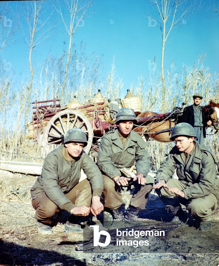 Three United States GIs from the 85th Infantry Division (Custer Division) keeping warm near a fire, Italy, April 1944 (photo)