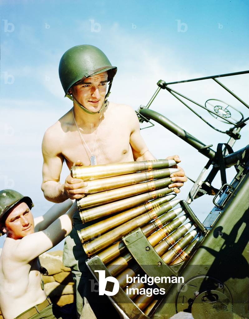 An American GI loading a Bofors 40mm anti-aircraft gun on the coast of England, June 1944 (photo)