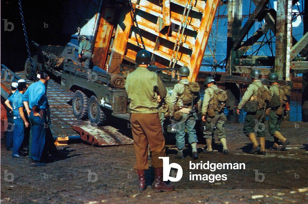 U.S. troops and vehicles embarking on a Landing Ship Tank (LST) in a port in Southern England, June 1944 (photo)
