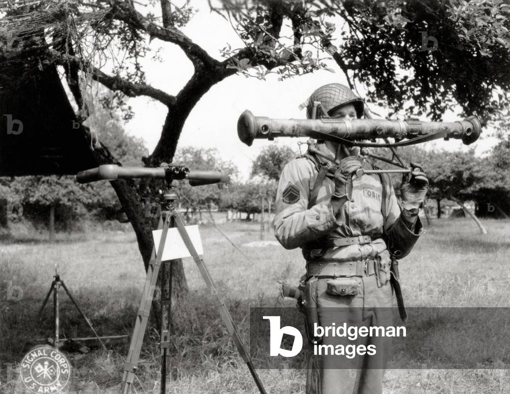 Staff Sergeant John O'Brien of the 116th Infantry Regiment of the 29th Infantry Division during a presentation of a German rangefinder for Flak, Saint-Clair-sur-l Elle, Normandy, France, June 1944 (b/w photo)