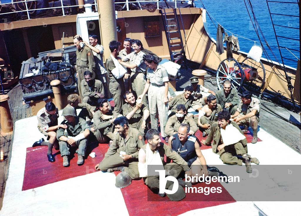 A group of 15 injured soldiers on deck, attended by six nurses, June 1944 (photo)