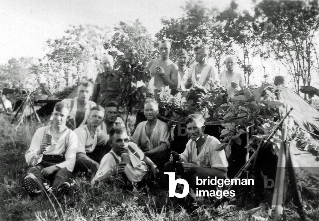 Twelve young soldiers of the Wehrmacht with a tent in the forest, France, 1944 (b/w photo)