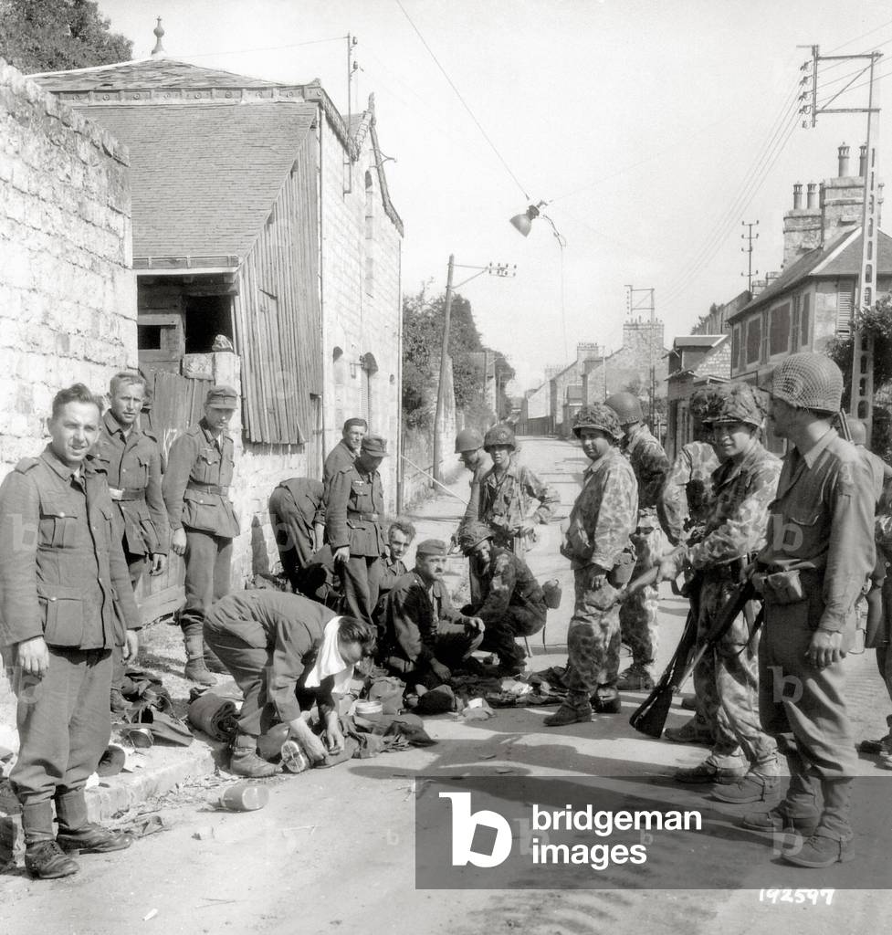 American soldiers guarding German prisoners in the Rue des Fosses, Domfront, Normandy, France, August 1944 (b/w photo)