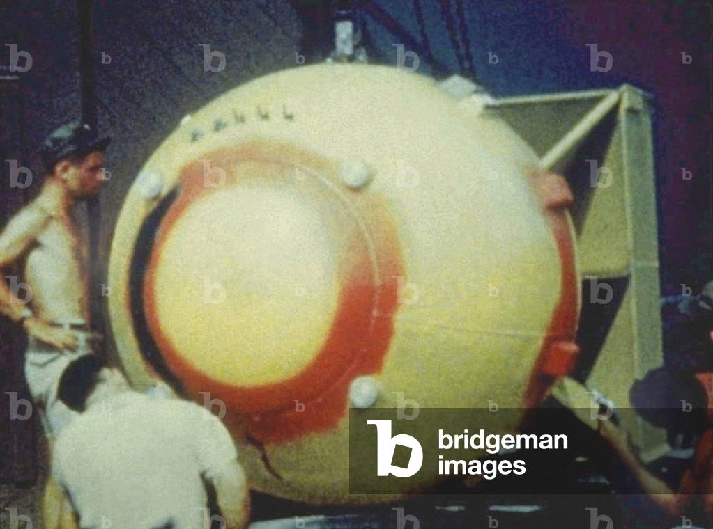 Technician spraying 'Fat Man' bomb with plastic paint in front of Assembly Building Number 2, Tinian, Mariana Islands, August 1945 (photo)