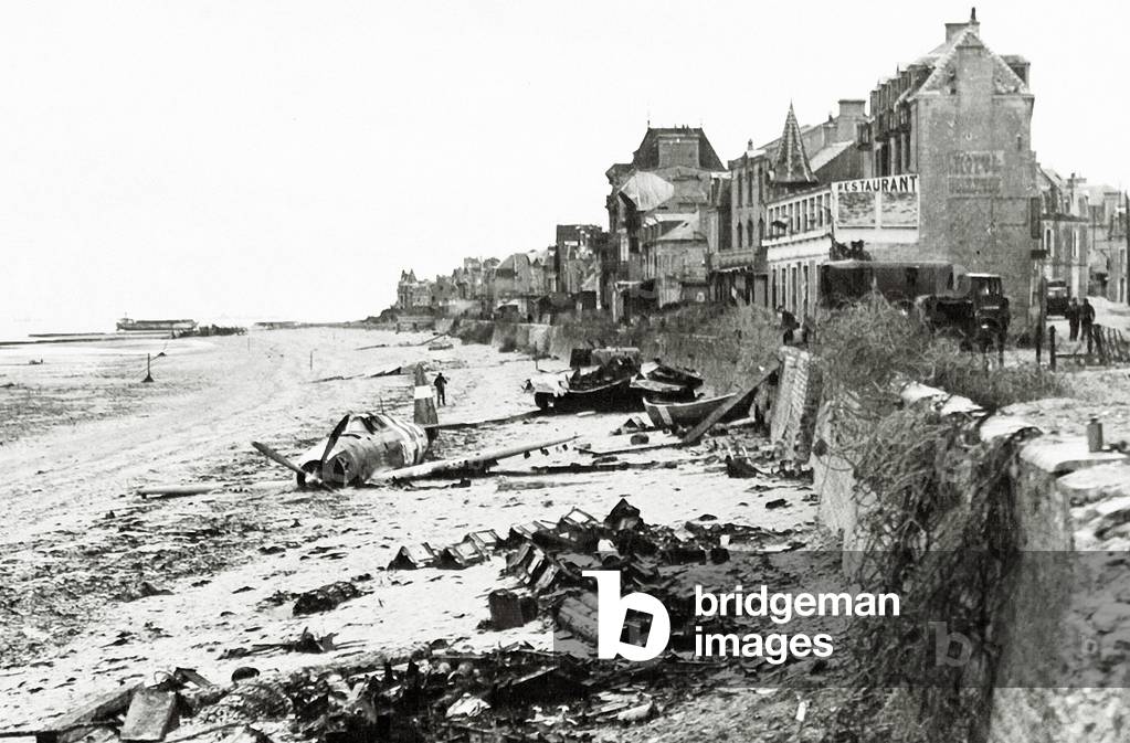 A Republic P-47 has crashed on the beach, which is littered with scrap, Normandy, France, June 1944 (b/w photo)