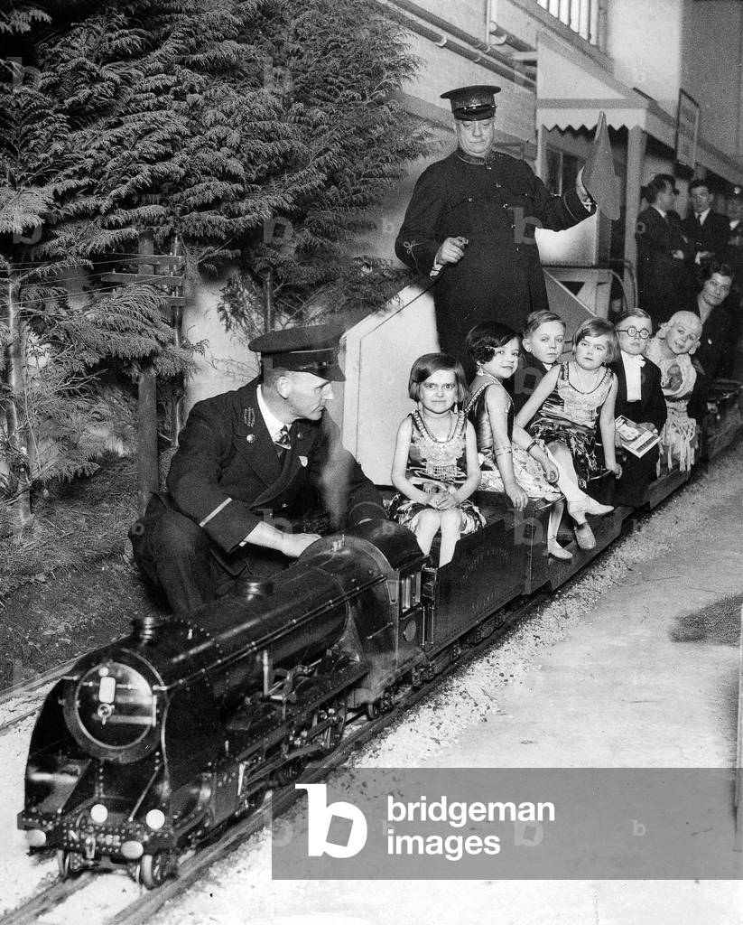 Midgets from Bertram Mills' Circus from London go for a ride on the miniature railway at the Daily Mail Schoolboys' Exhibition in London, 30's