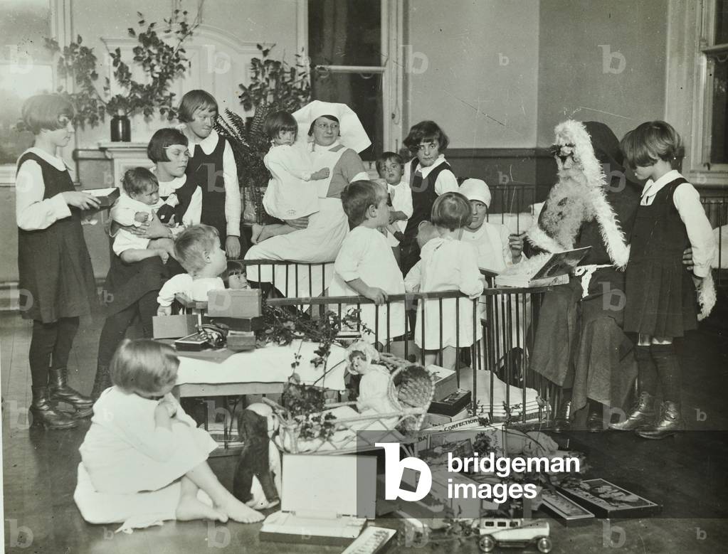 Children receiving Christmas presents from Father Christmas in a hospital (b/w photo)