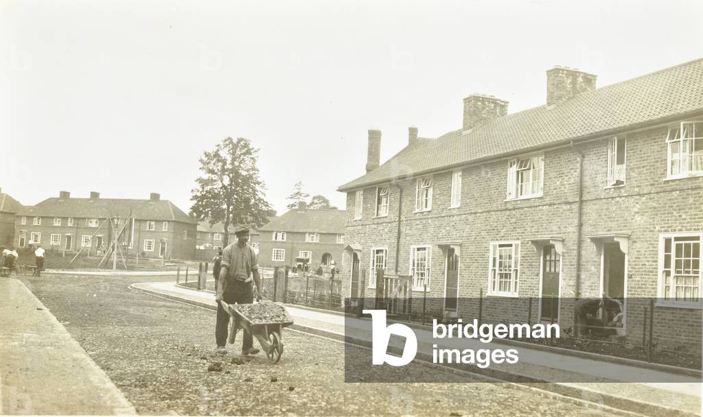Saint Helier Estate: Construction progress, workman with wheelbarrow, London, 1925 (b/w photo)