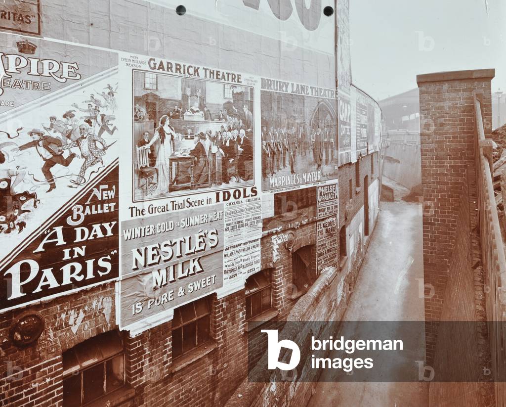 Clapham Junction Station: advertising boards include Garrick Theatre, Drury Lane Theatre, the Empire Theatre and Nestle's Milk, 1908 (b/w photo)