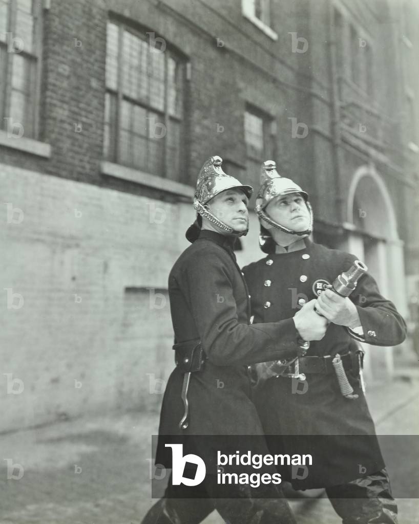 London Fire Brigade: two firemen with a fire hose, 1936 (b/w photo)