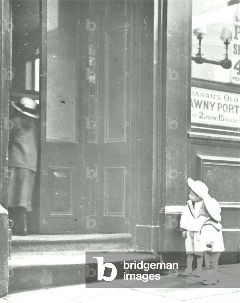 Two small children in sailor suits outside a pub, London, 1918 (b/w photo)