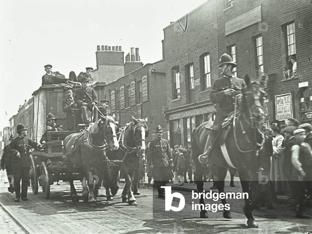 Valuable cargo making its way down East India Dock Road, with police escort, London, 1912 (b/w photo)