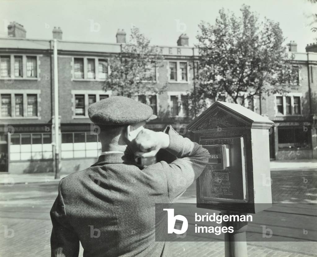 Fire Brigade instructional photograph: demonstration of operating alarm, 1936 (b/w photo)