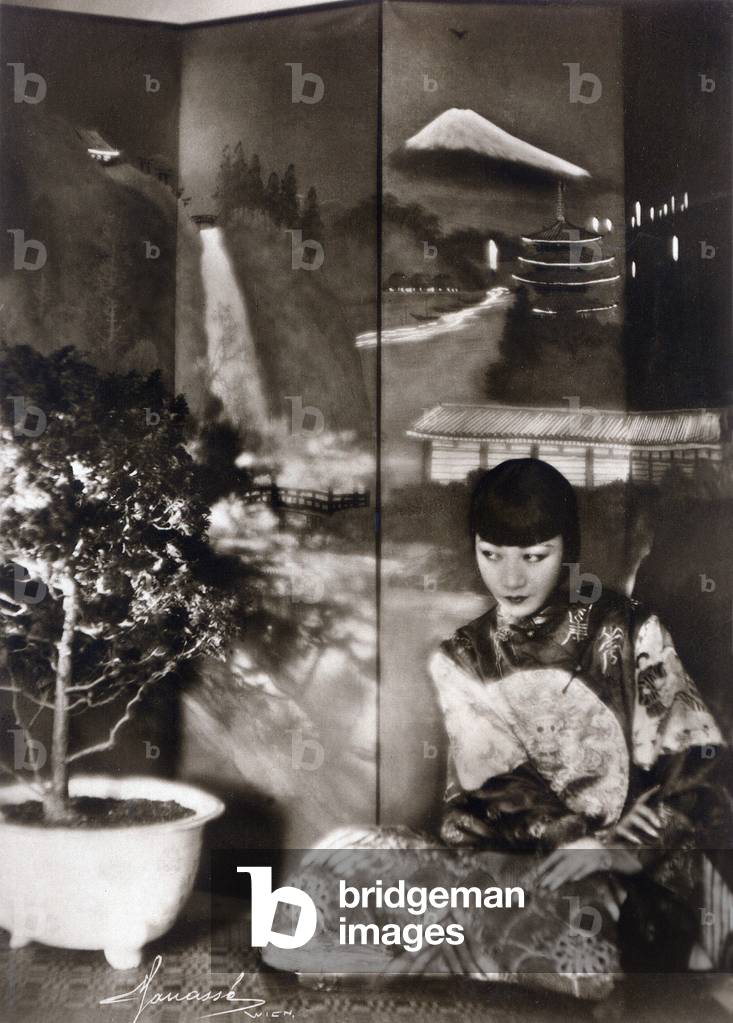 Portrait of actress Anna May Wong dresses in the fashion of crazy years, leaning on a screen, 1920's Photo Manasse