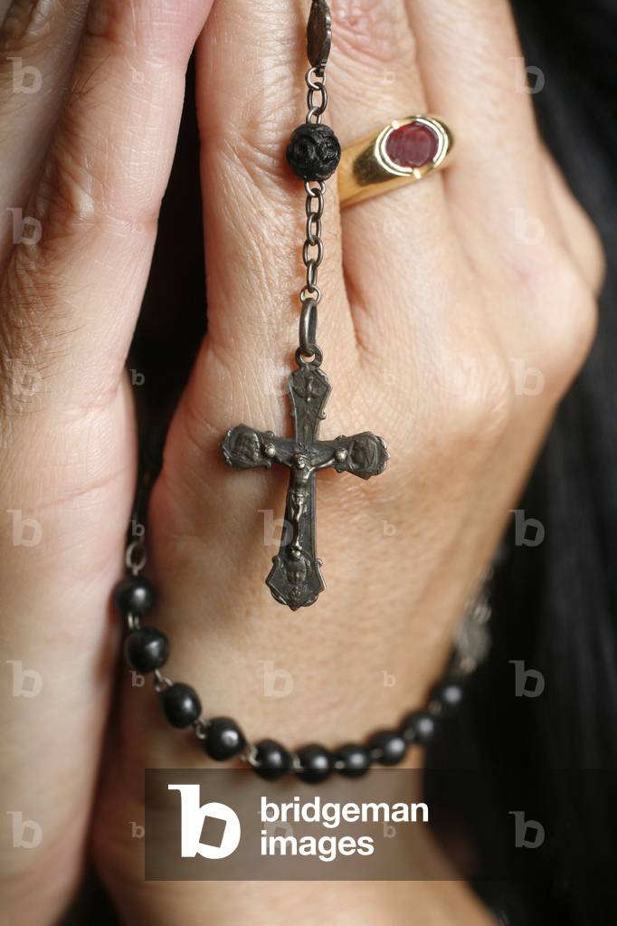 Woman praying with rosary Chatillon-sur-Chalaronne France