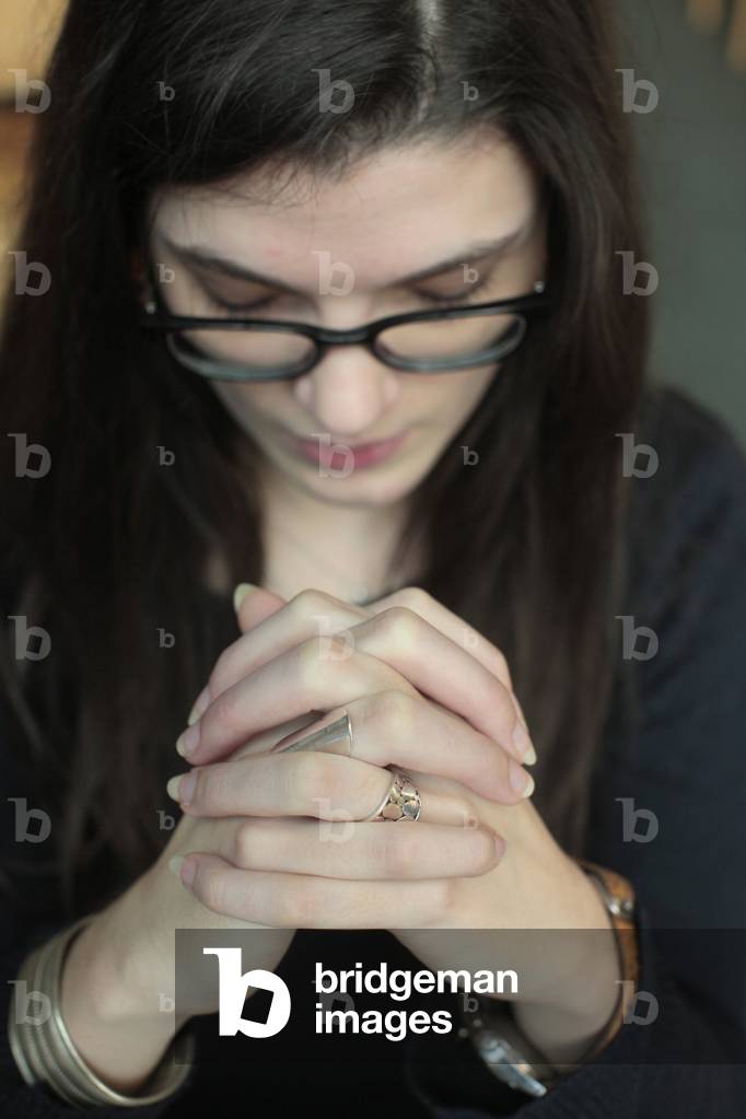 Young woman praying in a church ; Paris France
