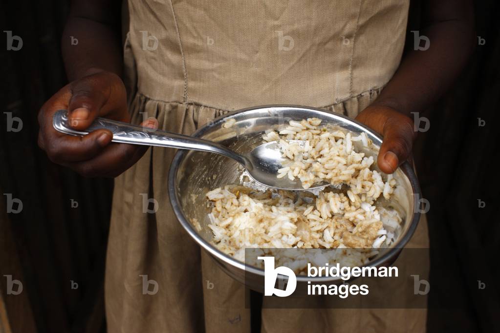 African girl eating rice, Lome, Togo