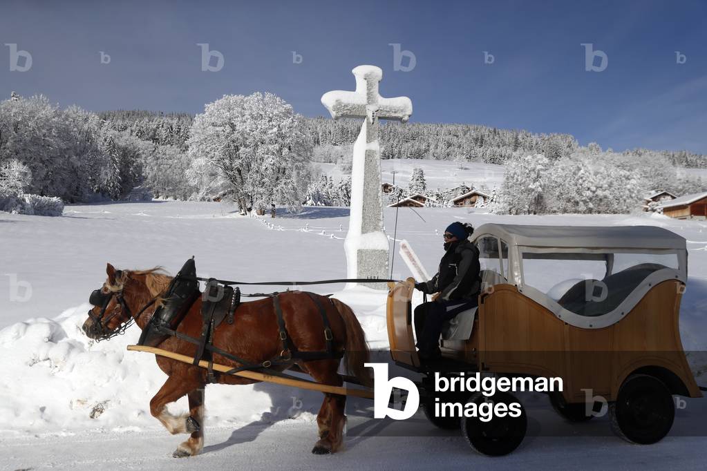 Stone cross with snow in winter, Megeve, France (photo)