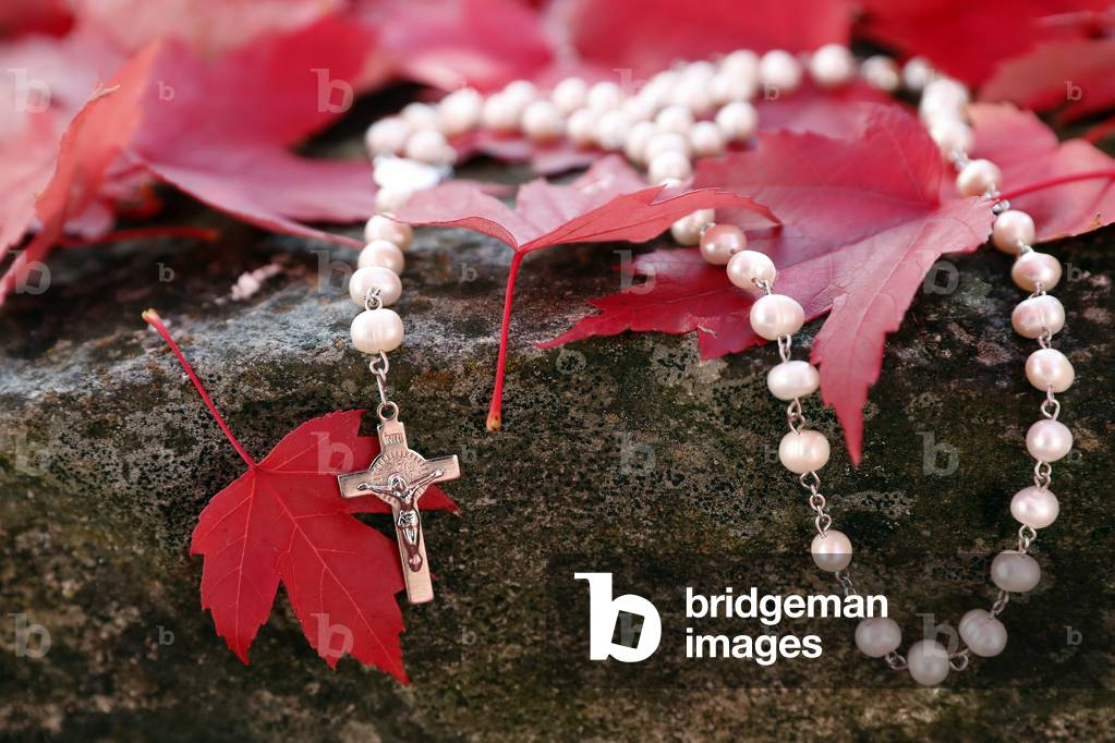 Catholic rosary on fall red leaves. Autumn.  France.