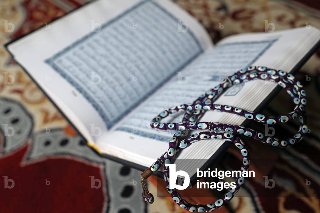 Holy Quran in arabic and muslim prayer beads on wood stand, 2019 (photo)