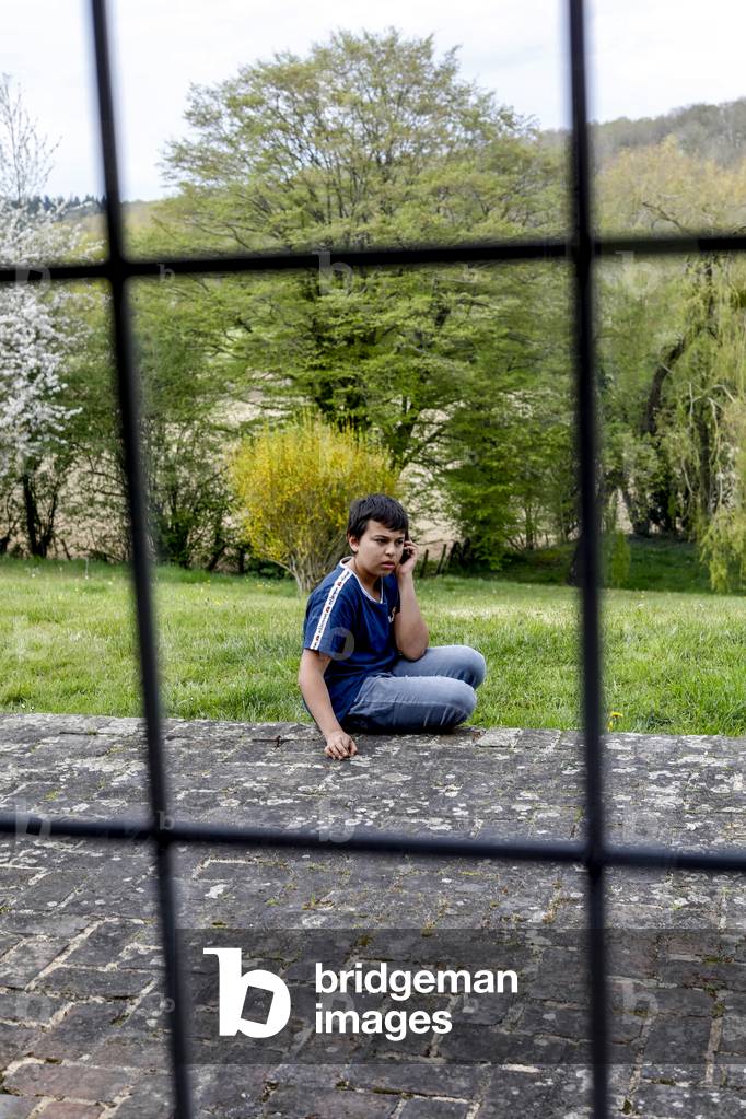 Boy using a cell phone. Eure, France.