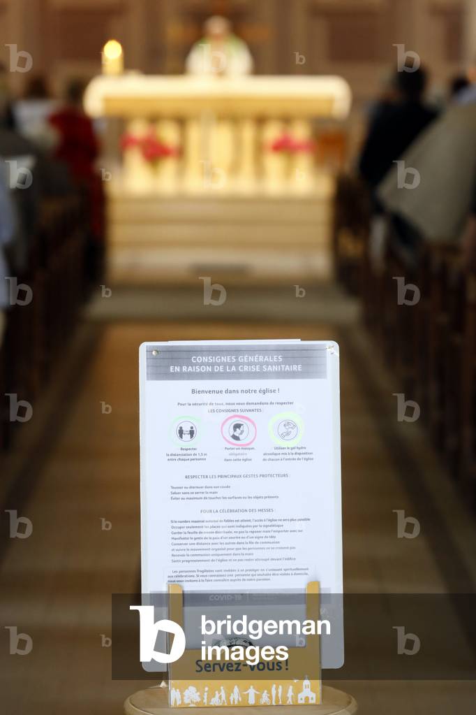 Church during the Coronavirus epidemic. COVID-19 instructions : sanitizing gel, surgical mask and social distancing.  France.