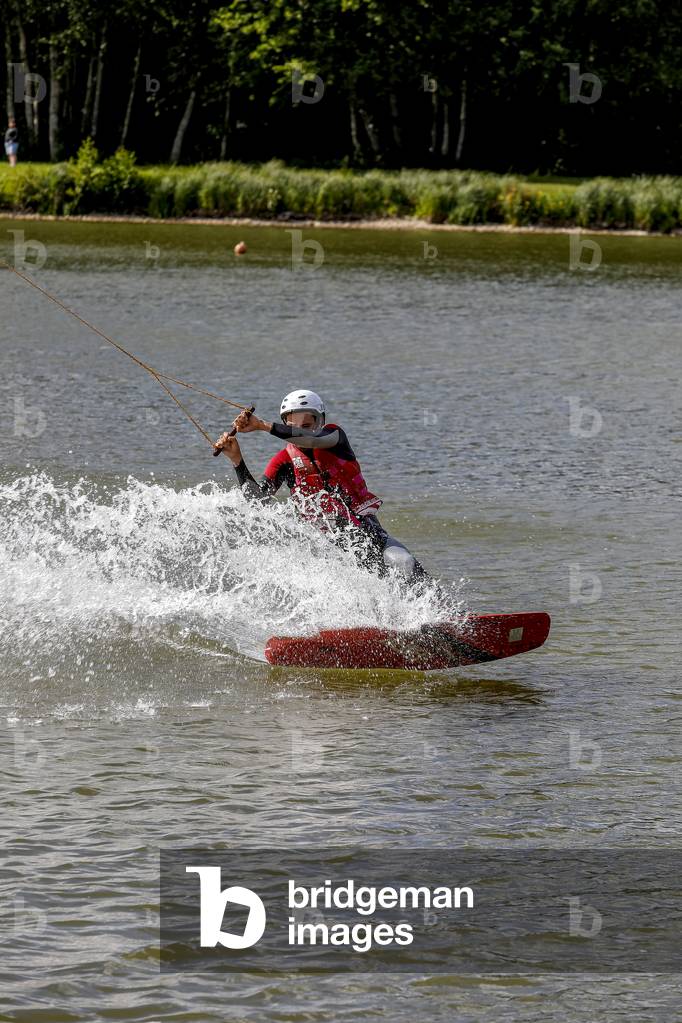 Young man wakeboarding in Damville, France.
