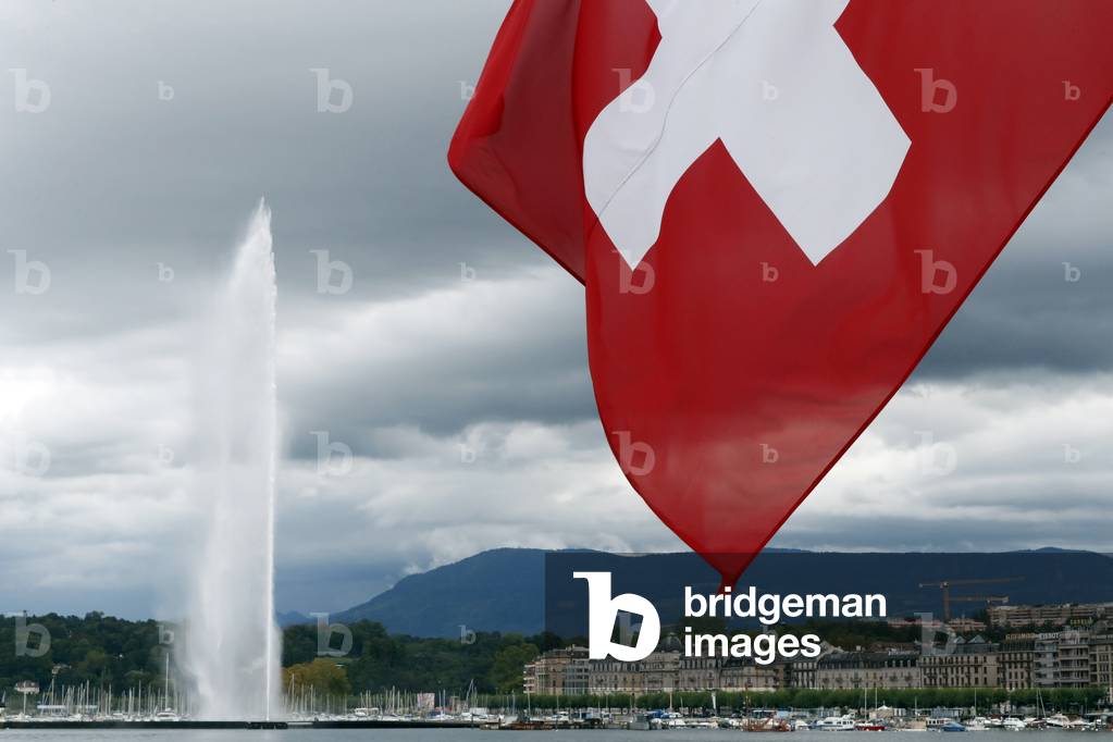 Swiss flag and Jet d'Eau, the world's tallest fountain, on Lake Geneva (Lake Leman).