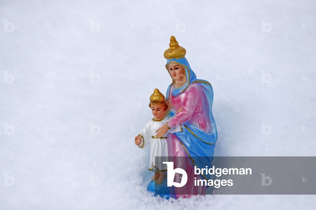 Holy Virgin and infant Jesus statue in snow.  France.  (photo)