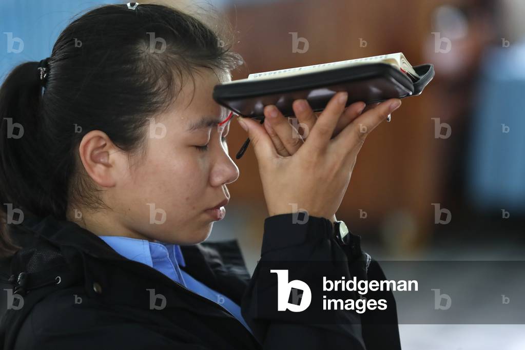 Catholic woman reading the bible in church, Basilica of Our Lady of La Vang, Pilgrimage, La Vang, Vietnam, 2019 (photo)