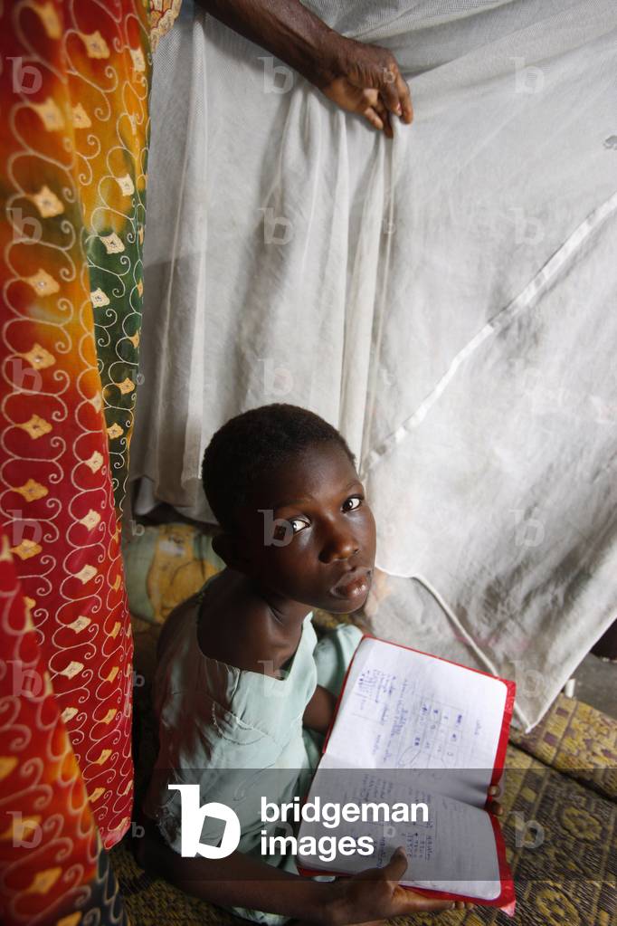 African girl doing homework in her room, Lome, Togo