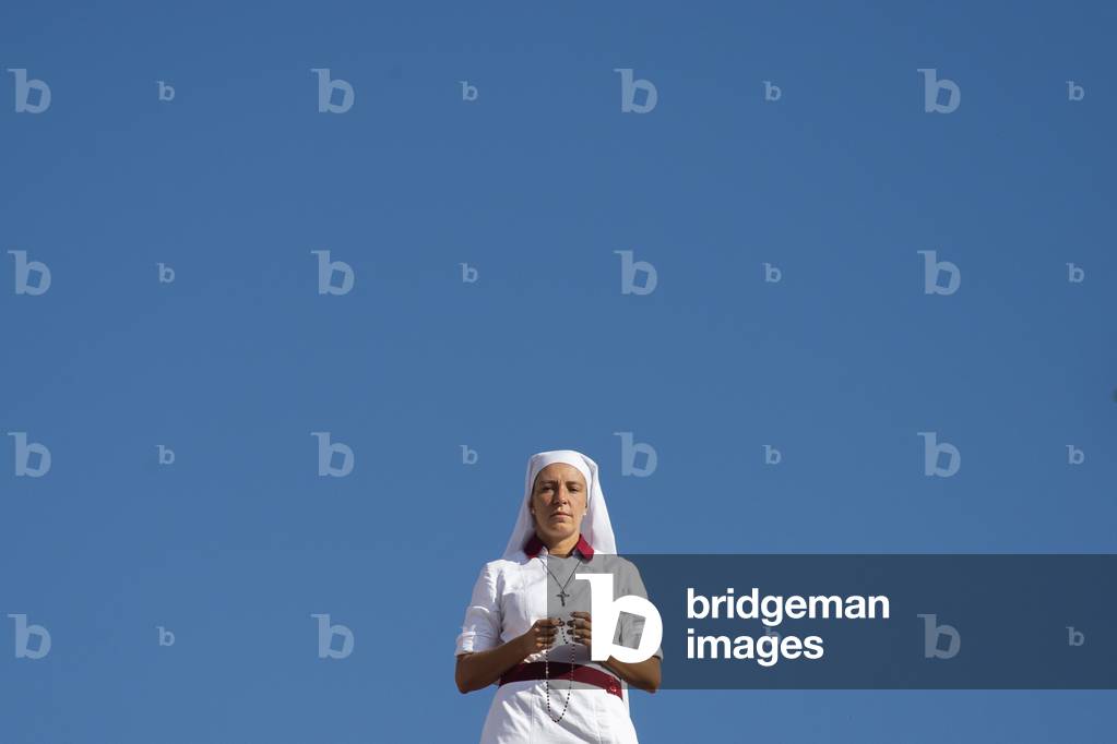 A Nun Praying the rosary before a Canonization Holy Mass in Saint Peter's square at the Vatican.