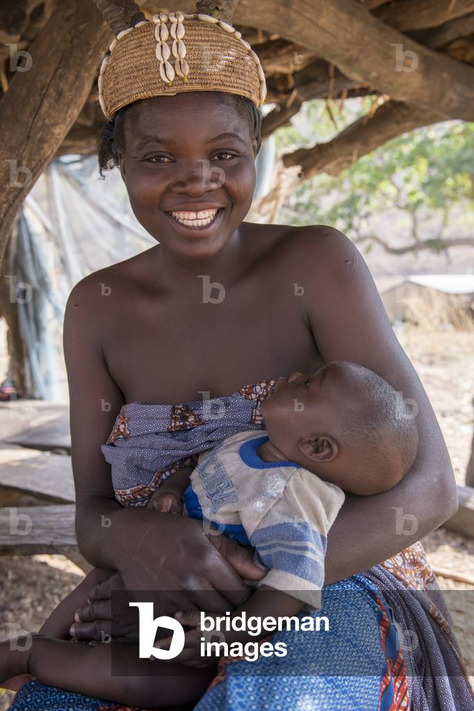 Young Batammariba woman  holding her sleepy child at Koutammakou village, Togo.