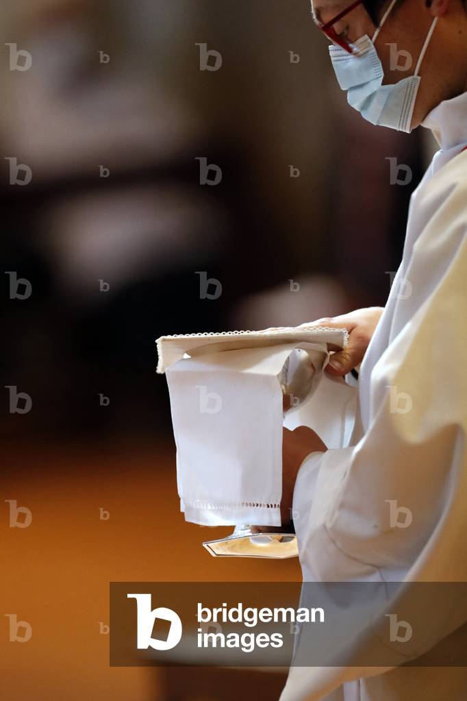 Catholic church during covid-19 epidemic. Sunday mass.  Altar boy at eucharistic celebration.  Sallanches.  France.