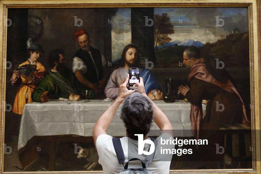Louvre museum, Paris, France. Visitor looking at a Tiziano painting.
