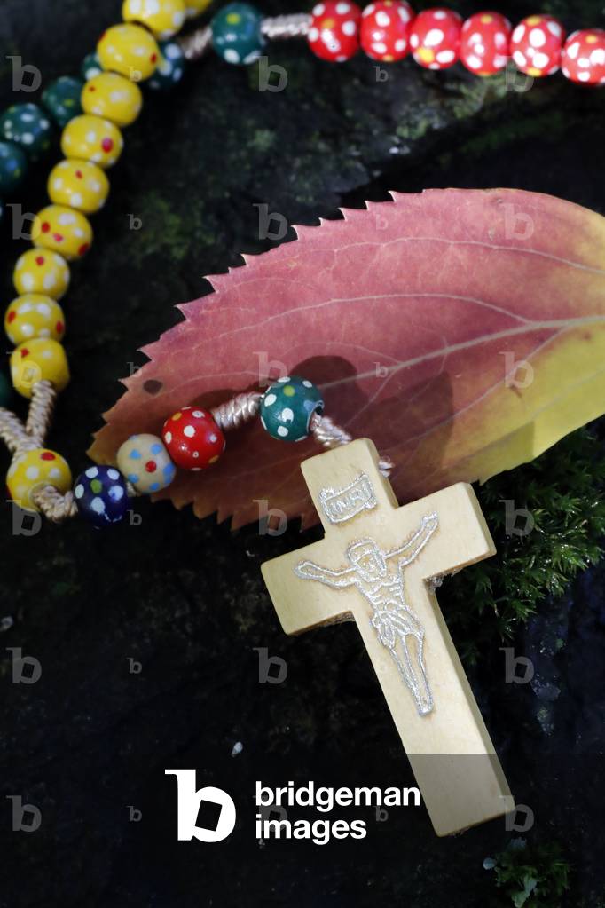 Catholic church. Wooden rosary with autum leaf.  France.